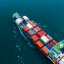 Overhead view of a freight ship carrying multicolored containers on a blue ocean