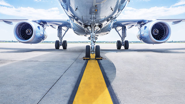 A commercial airline plane landing on the yellow line of a runway