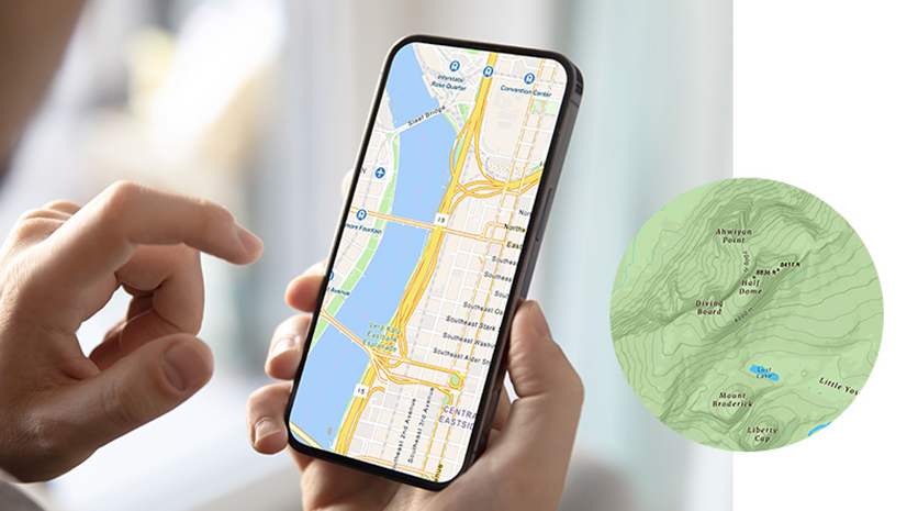 A pair of hands holding a mobile phone displaying a highway map