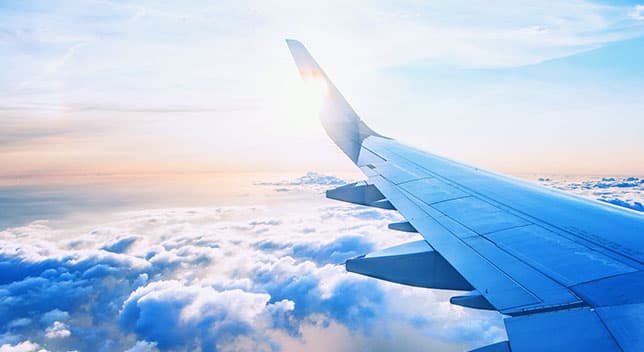 A wing of an airplane above the clouds