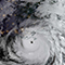 A satellite photo of a swirling tornado weather formation overlaid with a cluster map with gold points on a blue background