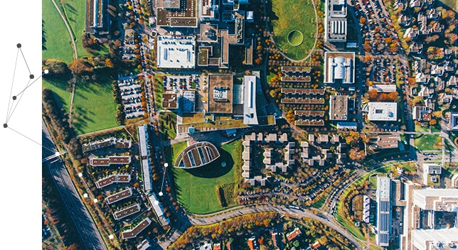 An aerial view of a cluster of buildings on a green field