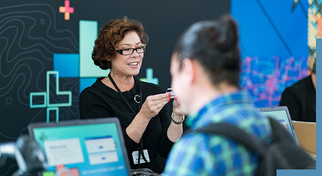 A woman at a conference registration desk