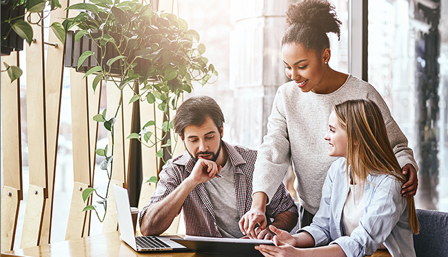 Three people looking at a laptop