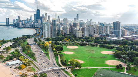 City landscape with park, lake, highway, and tall buildings