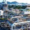 A photo of an industrial complex full of large silver pipes against a cityscape lit by pale early morning light