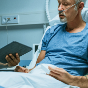 Person in a hospital bed talking with a doctor