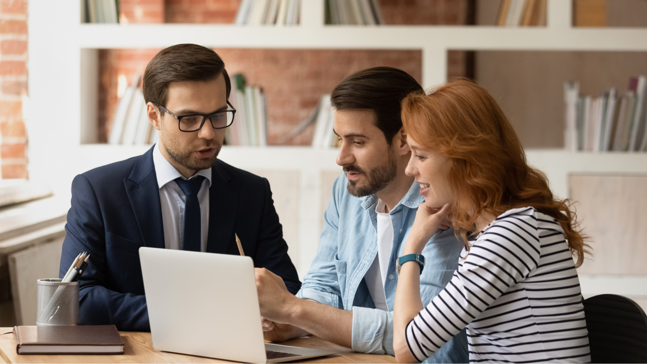 Three people looking at a laptop computer