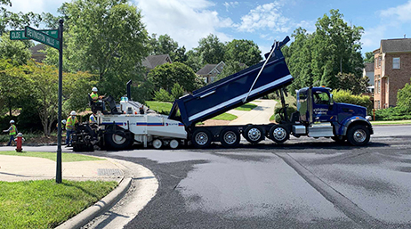 Workers using road pavement equipment on a neighborhood street 