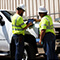 Two fieldworkers looking at a tablet while standing near a pickup truck